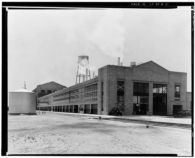 Ford Long Beach Assembly Plant Apr 24, 1931, EXTERIOR-PRESSED STEEL BUILDING, NORTH AND EAST SIDES, WAREHOUSE IN BACKGROUND, RAILROAD SPUR IN FOREGROUND, BONDERITE TANK AT LEFT