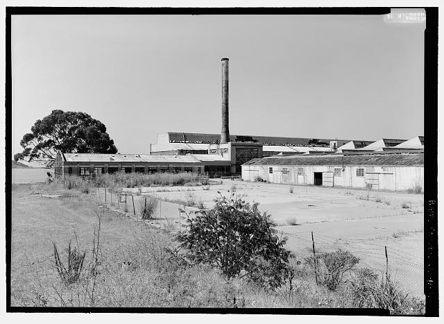 Ford Richmond Assembly Plant VIEW TO SOUTHWEST SHOWING OIL HOUSE (LEFT), BOILER ROOM AND STACK (CENTER), ROOF OF CRANEWAY (BACKGROUND), AND CRATING SHED (RIGHT).