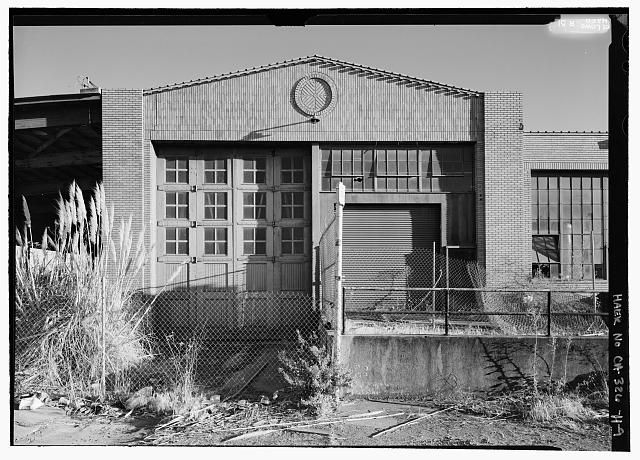 Ford Richmond Assembly Plant VIEW TO SOUTH SHOWING ENTRANCES TO BUILDING AT NORTHEAST CORNER. DOORS TO LEFT WERE FOR INTERIOR RAILROAD SPUR. ROLL-UP GARAGE DOOR TO RIGHT HAS REPLACED ORIGINAL PEDESTRIAN DOORS WHERE HOURLY SHIP WORKERS REPORTED TO WORK.