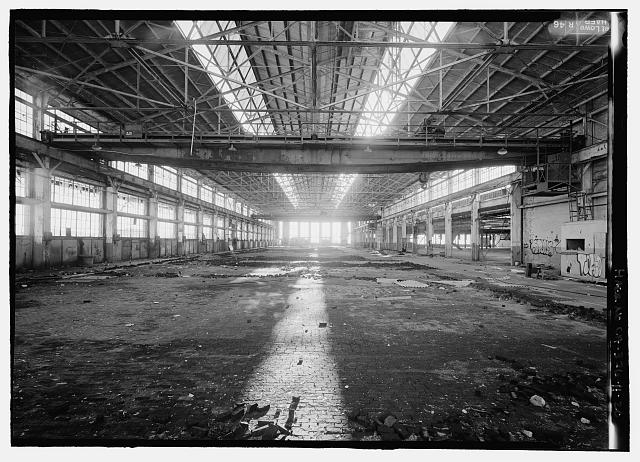 Ford Richmond Assembly Plant VIEW TO WEST OF INTERIOR OF CRANEWAY WITH TOW TRAVELING BRIDGE CRANES (ONE OVERHEAD IN FOREGROUND AND ONE OVERHEAD IN BACKGROUNDS). NOTE WOOD BLOCK PAVING ON THE FLOOR. FIRST FLOOR ASSEMBLY AREA IS THE SPACE IN THE BACKGROUND ON THE RIGHT.